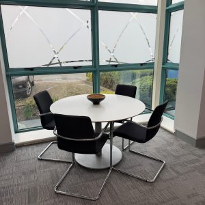 Meeting table and chairs with floor to ceiling windows in serviced office suite.